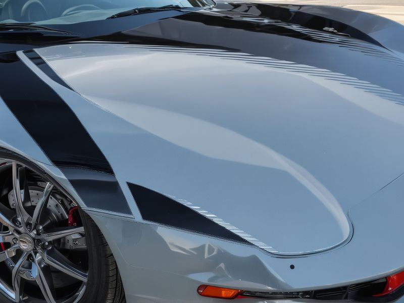 Close-up view of premium vinyl racing stripe installation showing professional technique and precision alignment